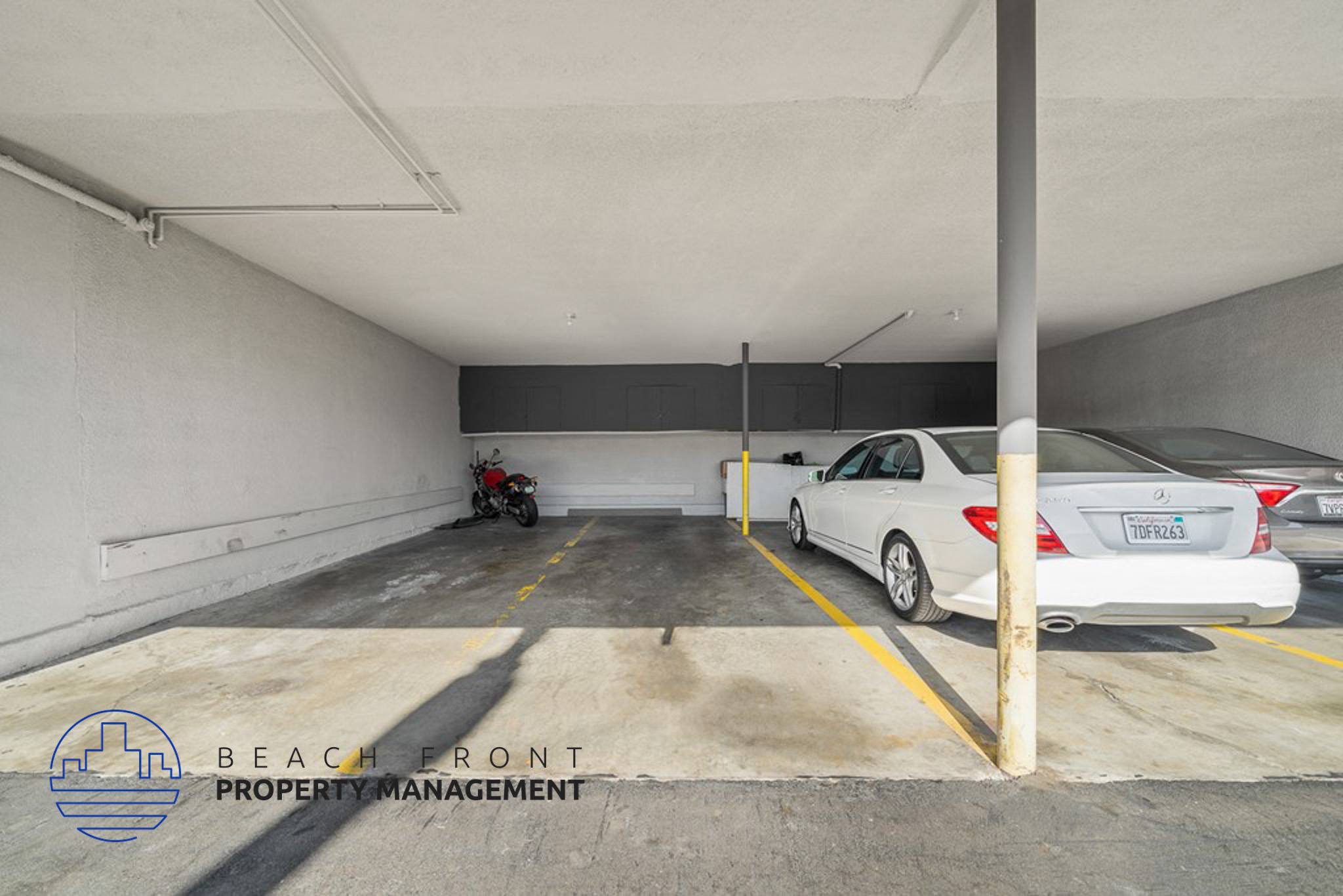 a parking garage with two cars and a motorcycle in it